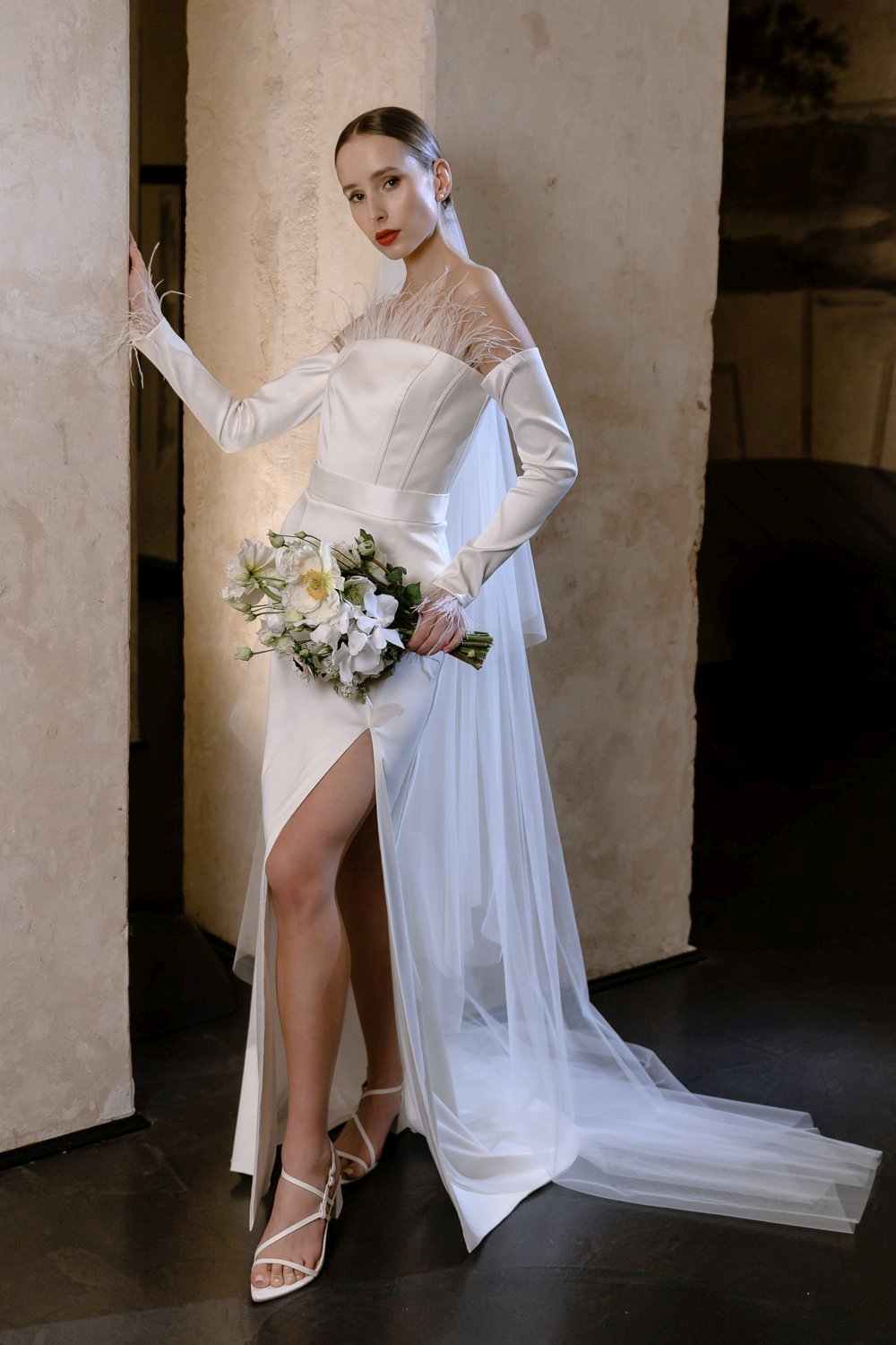 Minimalistinė vestuvinė suknelė atvirais pečiais ir plunksnų dekoru
